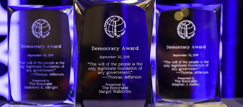 Three crystal democracy awards are engraved. blue background