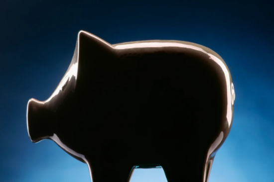 Piggy bank in shadow on dark blue backgroujnd